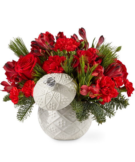 Red holiday flowers in a keepsake ornament vase