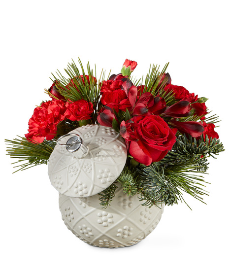 Red holiday flowers in a keepsake ornament vase