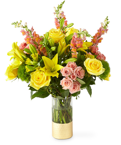 Yellow and peach flowers in a gold dipped tall glass vase