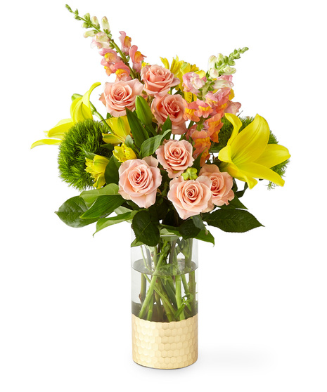 Yellow and peach flowers in a gold dipped tall glass vase