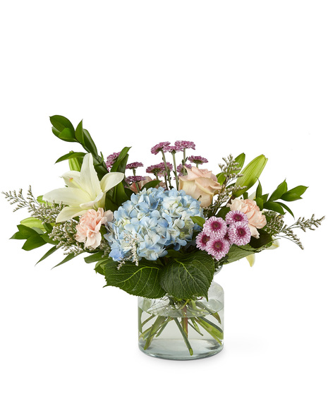 Mixed bouquet of flowers in a glass vase including hydrangea