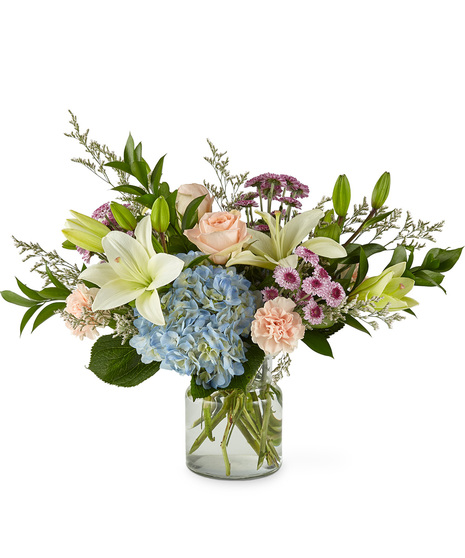Mixed bouquet of flowers in a glass vase including hydrangea