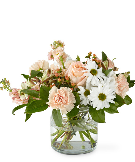 Bouquet of pastel peach florals in a glass vase