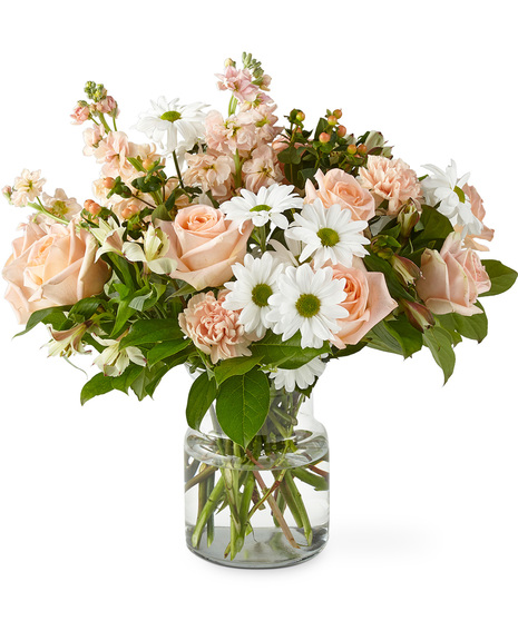 Bouquet of pastel peach florals in a glass vase