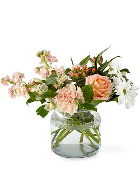 Bouquet of pastel peach florals in a glass vase