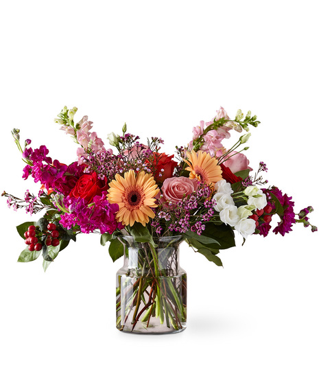 Premium florals including roses, lisianthus and snapdragons in a glass vase