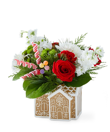 Christmas flowers arranged in a gingerbread house container