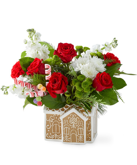 Christmas flowers arranged in a gingerbread house container