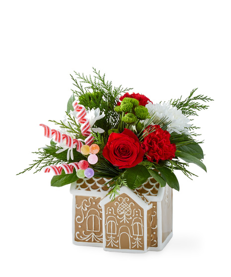 Christmas flowers arranged in a gingerbread house container