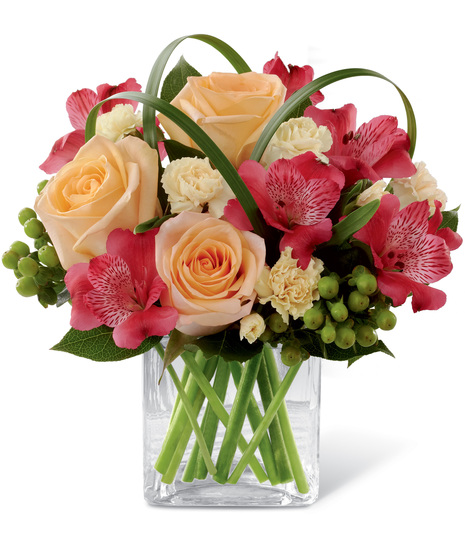 Red, peach and yellow flowers in a cube vase