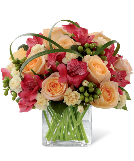 Red, peach and yellow flowers in a cube vase