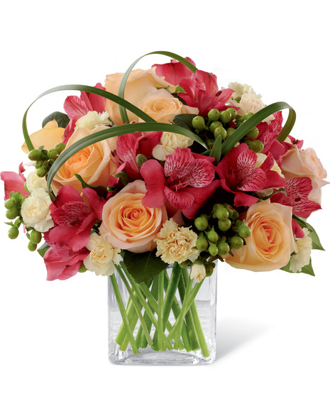 Red, peach and yellow flowers in a cube vase
