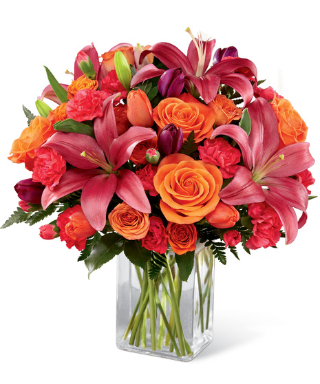 Bold colour flowers in a flat sided glass vase