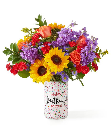 birthday flower arrangement with sunflowers peach roses lavender stock and red carnations in a happy birthday vase