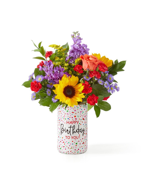 birthday flower arrangement with sunflowers peach roses lavender stock and red carnations in a happy birthday vase