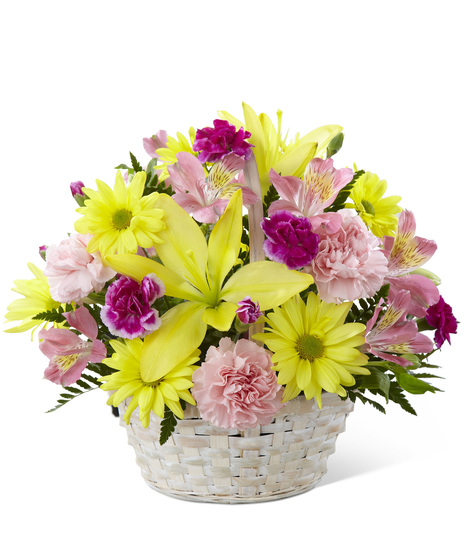 A handled basket of yellow and pink flowers