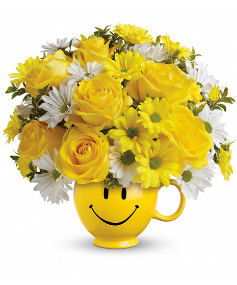 Yellow and white flowers in a happy face mug