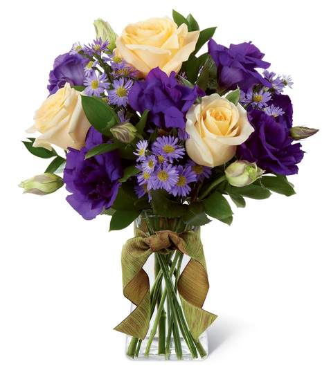 Cream and purple flowers in a glass vase