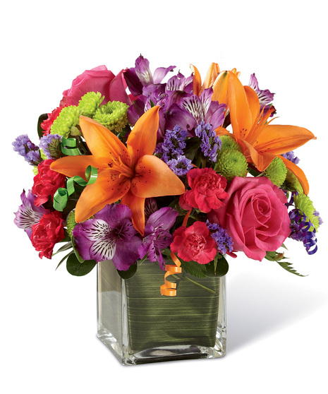 Vibrant birthday flowers in a clear glass  cube