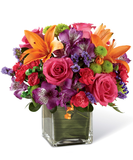Vibrant birthday flowers in a clear glass  cube