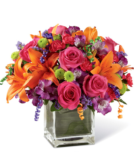 Vibrant birthday flowers in a clear glass  cube