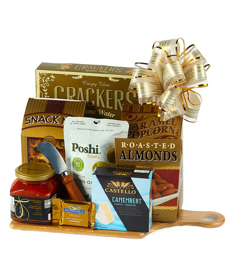 Epicurean Delight gourmet gift basket with crackers, chocolate, olives, popcorn, almonds, cheese, bruschetta, and cutting board wrapped in cello with a bow