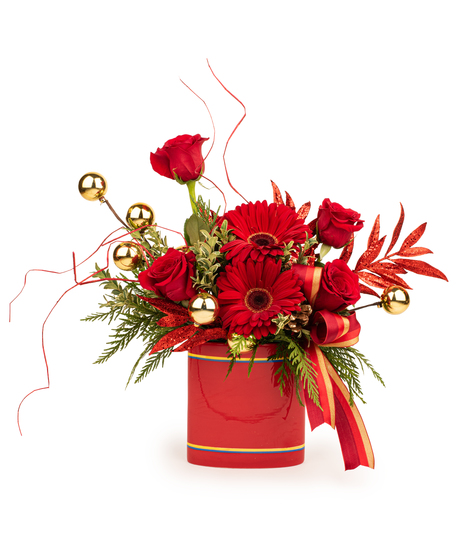 Golden Glow Holiday Bouquet with red roses, gerberas, gold ornaments, and festive ribbon in a red vase.