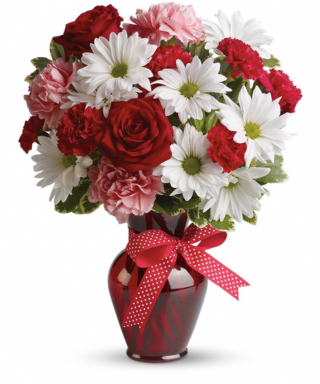 Red, white and pink flowers in a red glass vase