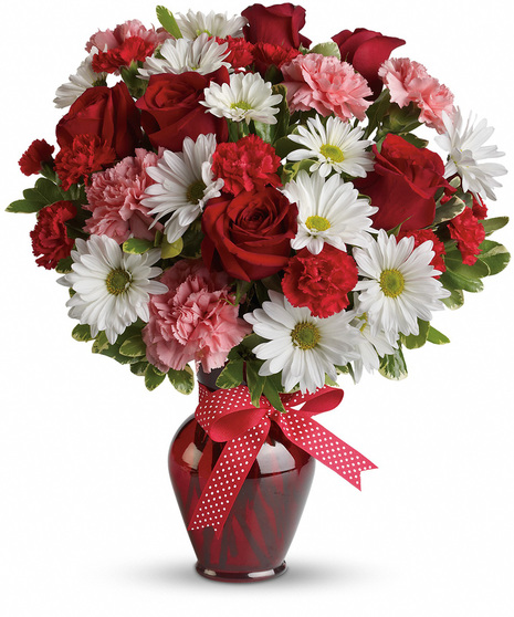 Red, white and pink flowers in a red glass vase