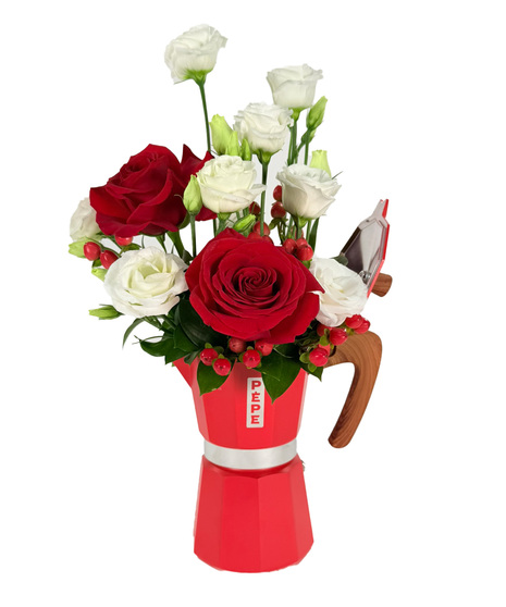 Red roses, white lisianthus, and berries arranged in a large red Pepe mocha coffee pot - a bold Mother's Day or all-occasion floral gift.