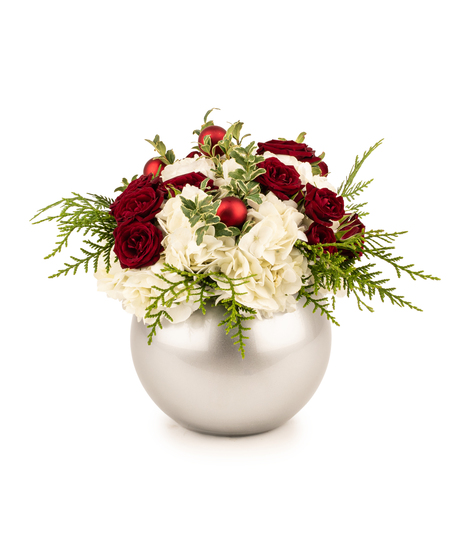 All-around Christmas centerpiece with hydrangeas, spray roses, red ornaments, and greens in an orb vase