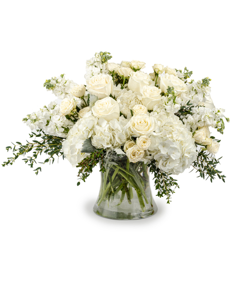 Luxury ivory and white rose bouquet with hydrangea arranged in a clear glass vase
