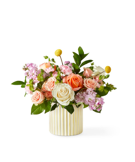 soft blush garden flower arrangement with roses stock and seasonal blooms in a modern ribbed vase