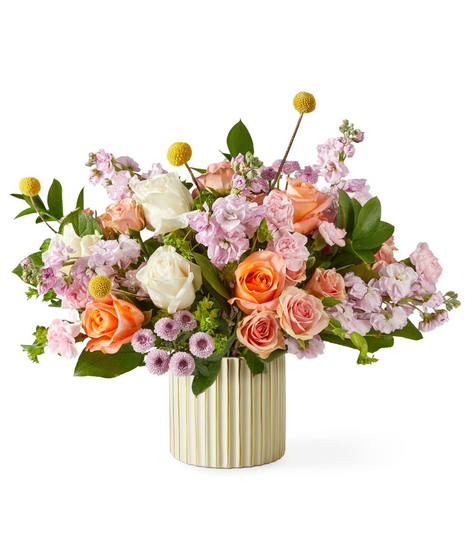soft blush garden flower arrangement with roses stock and seasonal blooms in a modern ribbed vase