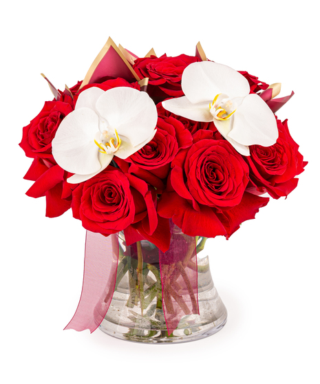 Eighteen red roses arranged in a clear glass vase with fresh green stems