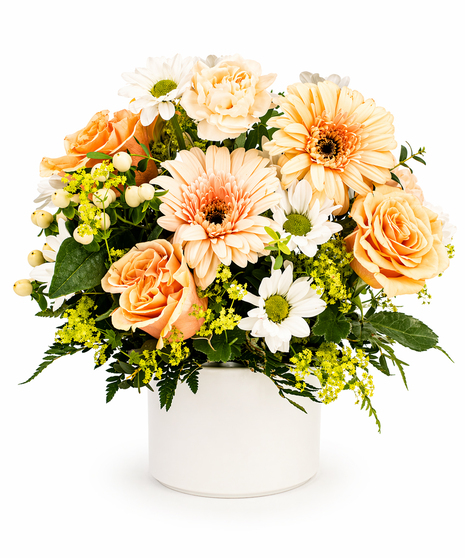 Peach Blossom Bouquet with peach gerberas, peach roses, daisies, carnations, hypericum, and solidago arranged in a small white flower pot.