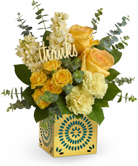 Yellow flowers in a shimmering metallic cut out vase