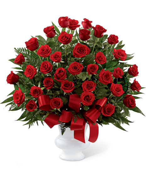 Red roses arranged in a white urn container