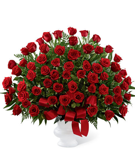 Red roses arranged in a white urn container