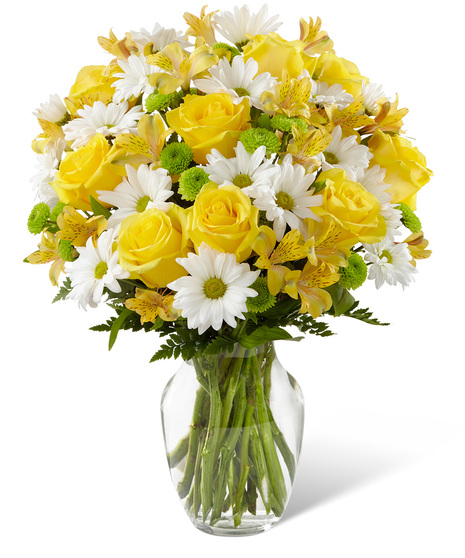 Yellow and white flowers in a glass vase