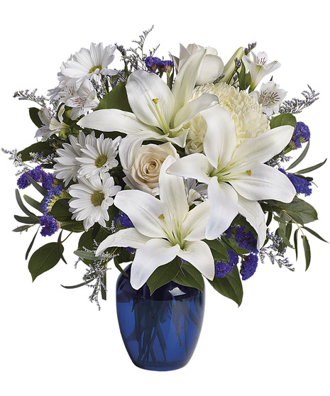 White and blue sympathy flowers in a blue vase