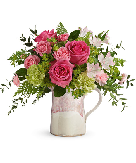 Pink flowers arranged in a stoneware pitcher
