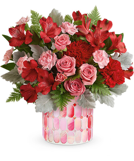 Red and pink Valentine's flowers in an artistic cylinder vase