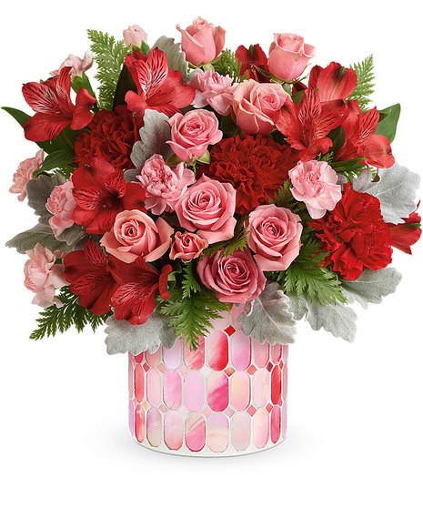 Red and pink Valentine's flowers in an artistic cylinder vase