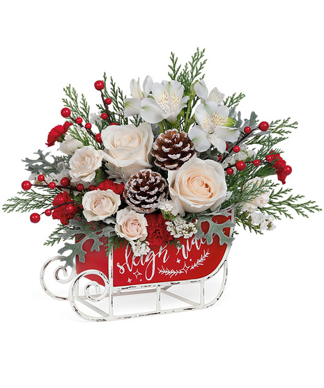 Christmas flowers arranged in a holiday sled