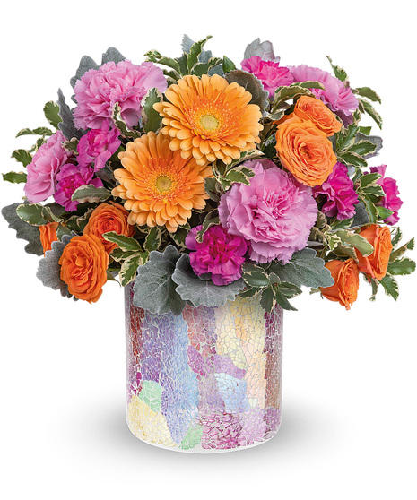 Orange, peach and pink flowers in a matching cylinder vase