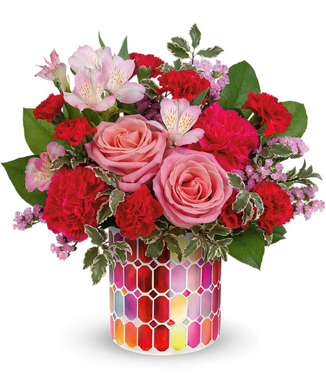 Pink and red flowers in a mosaic cylinder vase