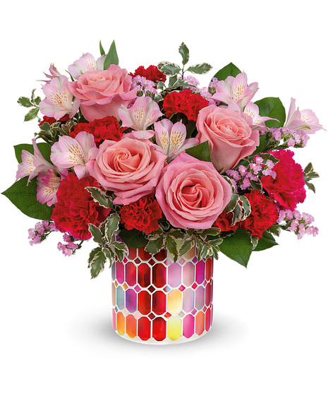 Pink and red flowers in a mosaic cylinder vase