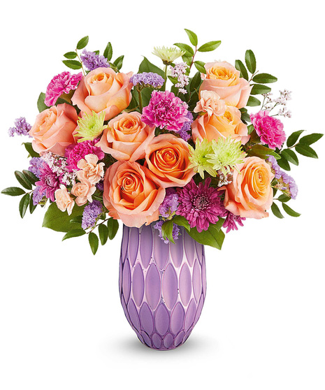 Purple, orange, pink and green mother's day arrangement in purple vase.