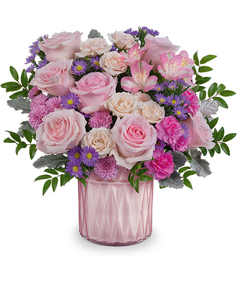 Pink purple and green mother's day arrangement in shiny pink vase.